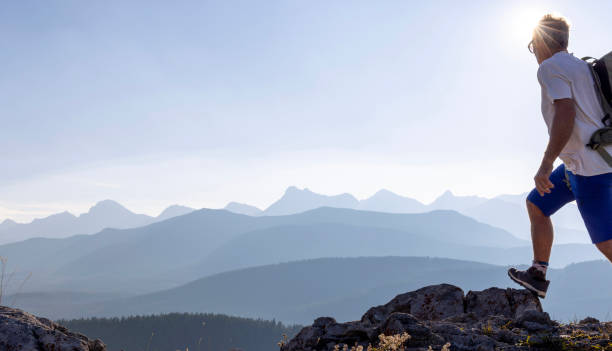Mature male hiker arrives on mountain summit