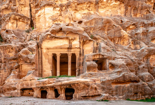 templo sobre las habitaciones de la cueva en siq al-barid, little petra, jordania. - petra antiquities jordan middle east fotografías e imágenes de stock