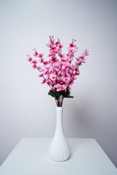 istock there is a white vase with pink flowers in it on a table 1659594050