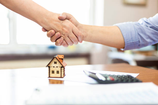 istock Real estate agent and customers shaking hands together celebrating finished contract 1659596408