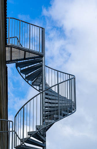 Germany, Berlin, August, 04, 2023 -Spiral fire escape at building against sky