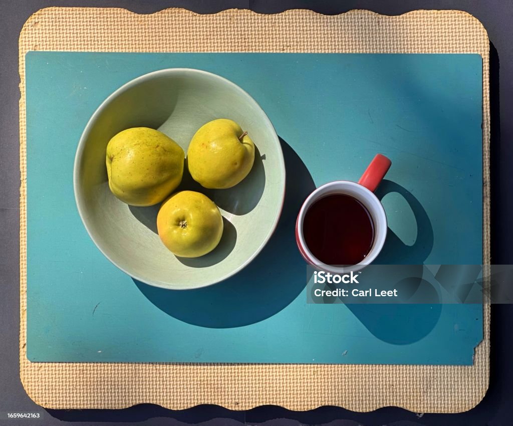 Yellow apples from the farmers market Three  yellow Apples in a bowl with a red coffee cup with a shaded background Apple - Fruit Stock Photo