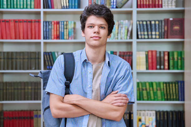 istock Portrait of confident guy college student looking at camera inside library 1659672892