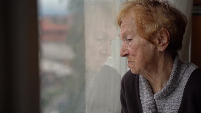 old woman looking out window