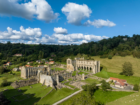 An aerial photograph of Rievaulx Abbey in the Rye Valley in the North Yorkshire Moors National Park. The photograph was produced on a bright sunny day. The Rievaulx Abbey was the first Cistercian monastery in Northern England