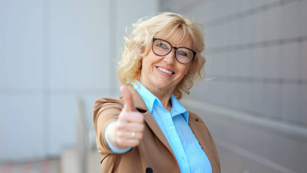 istock Positive female worker shows thumb up approving work 1659728773