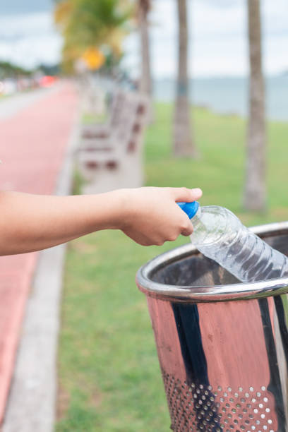 istock person throwing a plastic bottle in a trash can, recycling plastic 1659728944