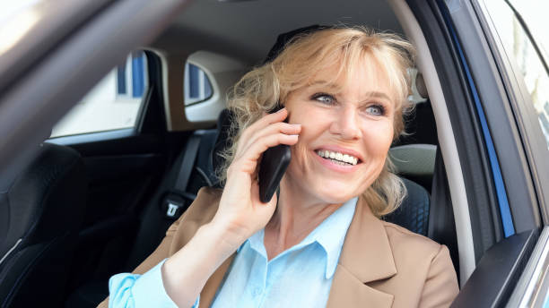 istock Female entrepreneur talks on smartphone sitting in vehicle 1659729475