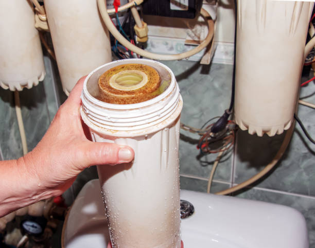 istock Women's hands remove flasks with contaminated water purification filters to be replaced with clean ones. The process of replacing the cartridges of a multi-stage water filter. 1659732668