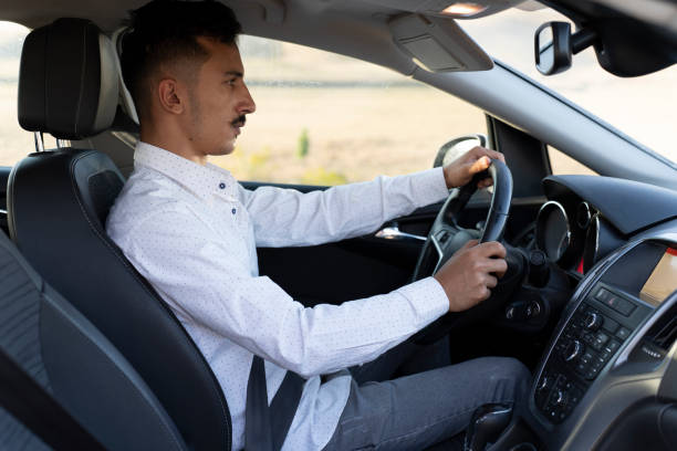 istock Young man driving a car. 1659766374