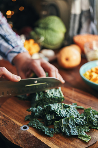 Cutting Kale for Vegan Pumpkin Kale Pot Pie for Thanksgiving in Domestic Kitchen