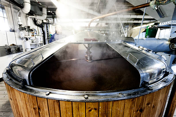 Mash tun and dissolving vat, brewing process Wooden mash tun and dissolving vats producing beer in a traditional Dorset brewery mixing vat stock pictures, royalty-free photos & images