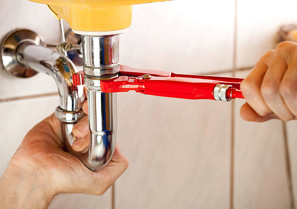 Plumber fixing a sink in bathroom