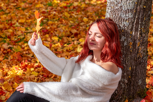 Autumn scenery with a young woman enjoying a sunny day in October in a colorful nature