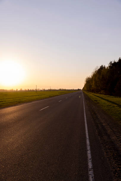 istock paved road at dusk during sunset, empty road 1659858503