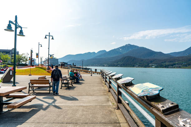 Juneau, Alaska - July 29, 2023: Tourists are walking on the boardwalk and enjoying the harbor view. Juneau Harbor and Cruise Pier view, Alaska, USA.