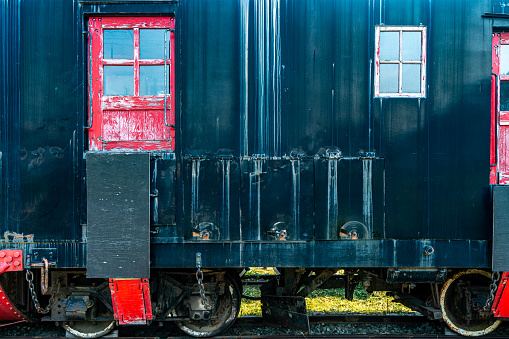 An old red wooden railroad caboose on track.