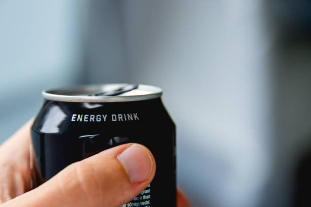 zbliżenie dłoni trzymającej puszkę napoju energetycznego - drink energy drink can isolated zdjęcia i obrazy z banku zdjęć