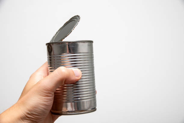 istock a hand holding tin canister on white background 1659866373