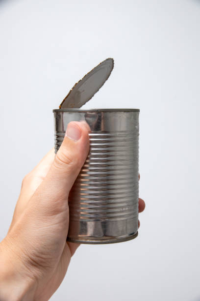 istock a hand holding tin canister on white background 1659866387