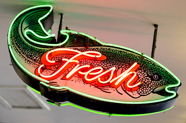 Classic Americana Neon Fresh Fish Shaped Sign A classic neon Fresh Fish Shaped sign. route 66 sign old road stock pictures, royalty-free photos & images