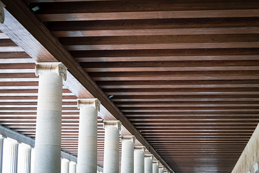 Wooden roof beams in a row with classical old greek columns in a patio in Athens, Greece
