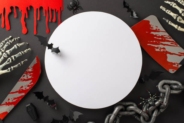istock Grim All Hallows' composition. Top view of theme components - captive's chain, skeleton hands, blood trickles, cleaver, knife, coffin. Sinister spiders, bats. Dark backdrop with blank circle for ad 1659934913
