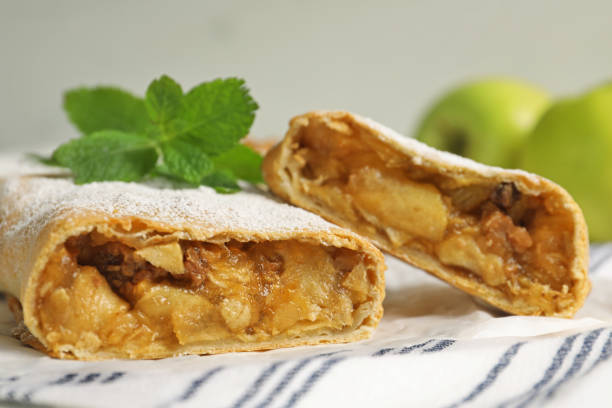 istock Delicious strudel with apples, nuts and powdered sugar on table, closeup 1659938793