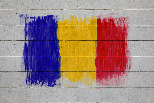 Close up of Romania flag colors red yellow and blue painted on brick wall