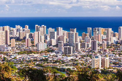Aerial view of Waikiki beach cityscape on a sunny afternoon with the Pacific Ocean in the background. Oahu, Hawaii.