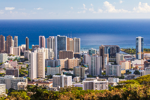 Aerial view of Waikiki beach cityscape on a sunny afternoon with the Pacific Ocean in the background. Oahu, Hawaii.
