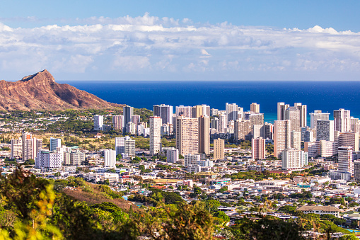 Mountain view of Waikiki beach cityscape on a sunny afternoon with the Pacific Ocean in the background. Oahu, Hawaii.