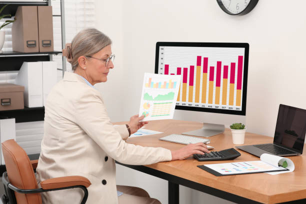 istock Senior accountant working at wooden desk in office 1659954257