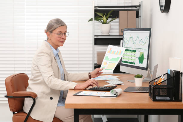istock Senior accountant working at wooden desk in office 1659955825