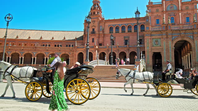 A beautiful tourist girl in a green dress walking in Plaza de España in Seville.