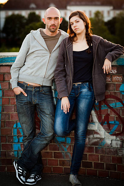 istock couple leans against a wall with cool attitude 165997873