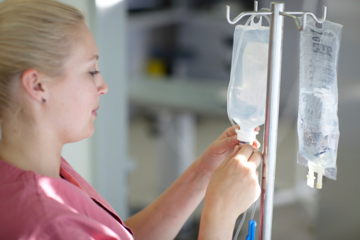 female medical assistant is preparing an infusion