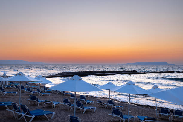 Twilight Tranquility: Afterglow on Crete's Beach with Concrete Breakwater