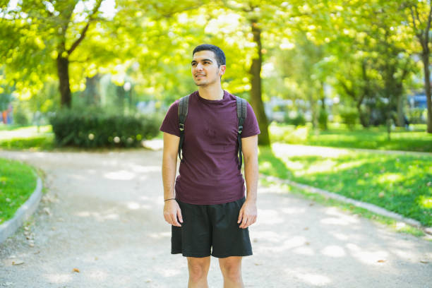 istock young man walking in the park 1660001028