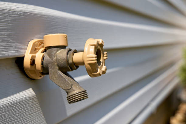 Outdoor water faucet on faux wood style siding