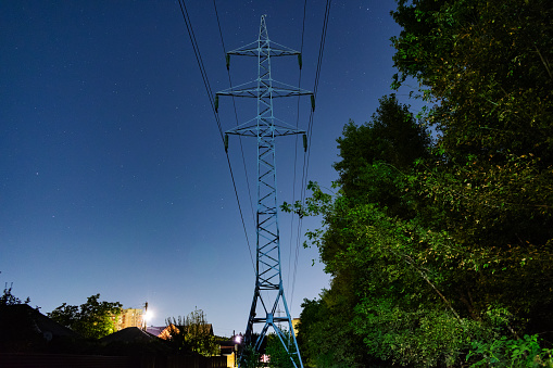 High-voltage pole on the background of the starry sky in the summer midnight
