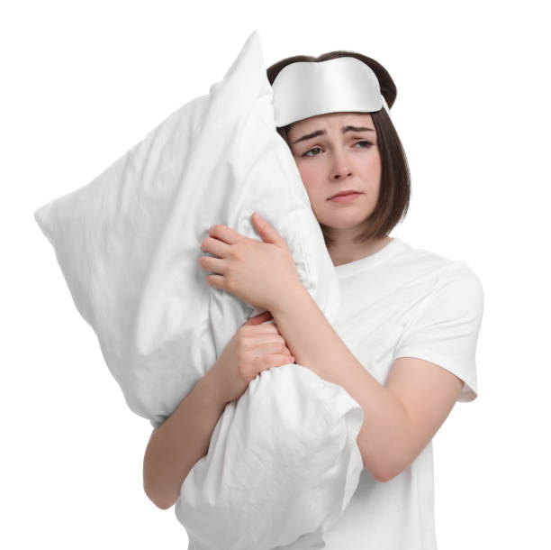 istock Unhappy young woman with sleep mask and pillow on white background. Insomnia problem 1660042875