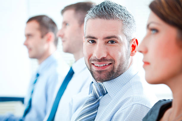 istock Man smiling in group of professionals 166004599