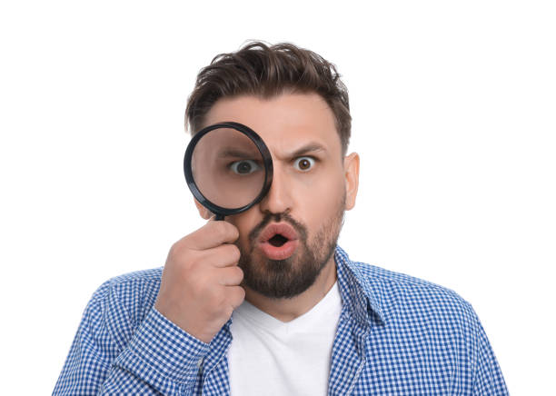 istock Emotional man looking through magnifier on white background 1660063996