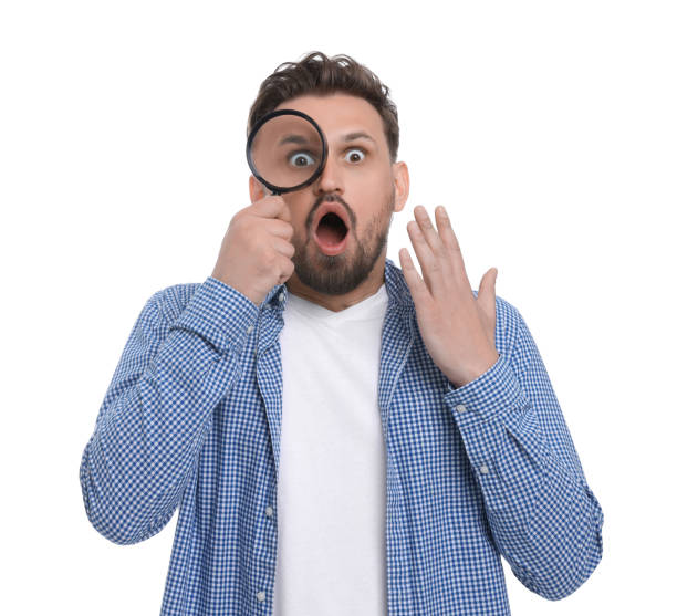 istock Emotional man looking through magnifier on white background 1660071195