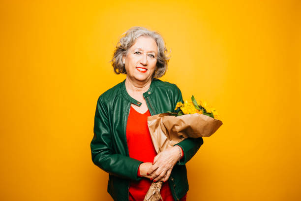 istock Senior smiling woman with a sunflowers. 1660122870