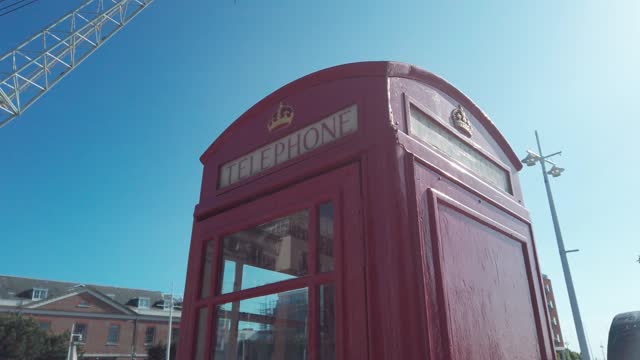 Red telephone booth against blue sky, a symbols of Great Britain, United Kingdom