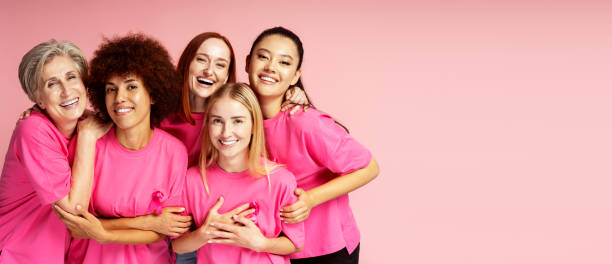 Women with pink ribbon isolated on background, copy space. Breast cancer awareness month Smiling women with pink ribbon isolated on background, copy space. Breast cancer awareness month 21 24 months stock pictures, royalty-free photos & images
