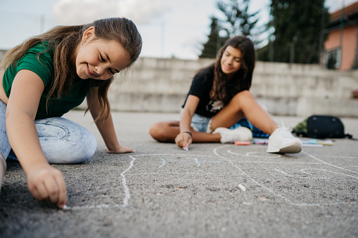 Children draw with chalk on the concrete