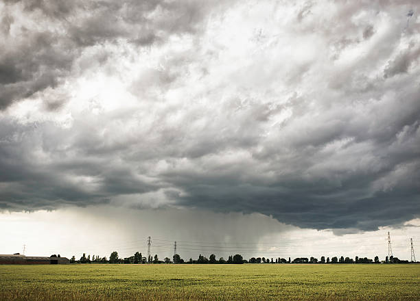 Cloudburst Heavy rain falling in the distance in rural Norfolk, England. heavy rainfall stock pictures, royalty-free photos & images